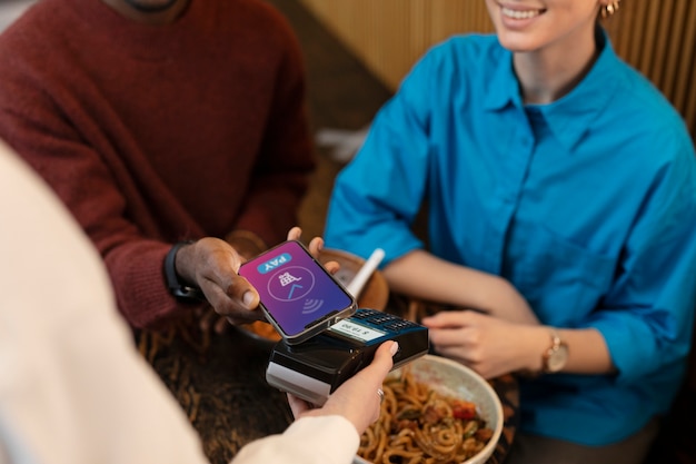 Foto persona que paga sin contacto por comida en un restaurante