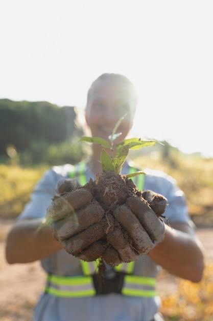 Foto persona que planta un árbol en el campo.