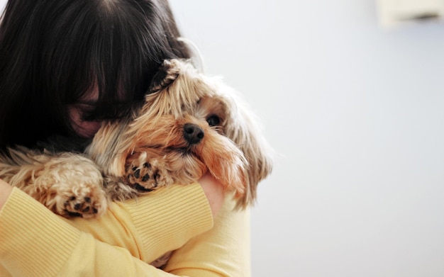 una persona que sostiene un perro con una persona que lo sostiene