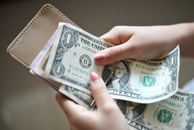 Una persona que sostiene una pila de billetes de un dólar