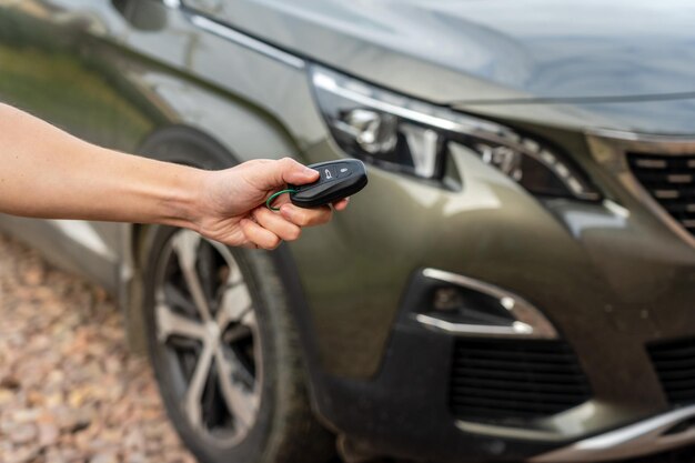 La persona que tiene la llave del auto en la mano se encuentra frente al préstamo del seguro del auto y compra el concepto del auto