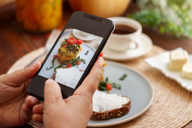 Foto persona que toma una foto de anillos de vegetales con un teléfono inteligente