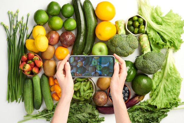 Persona que toma una foto de comestibles frescos