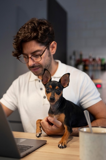 Foto persona que trabaja desde casa con perro mascota