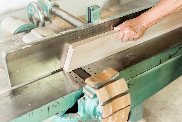 Persona que trabaja con una máquina cepilladora de madera, primer plano horizontal