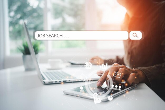Una persona que usa una computadora portátil con las palabras búsqueda de empleo en la pantalla.