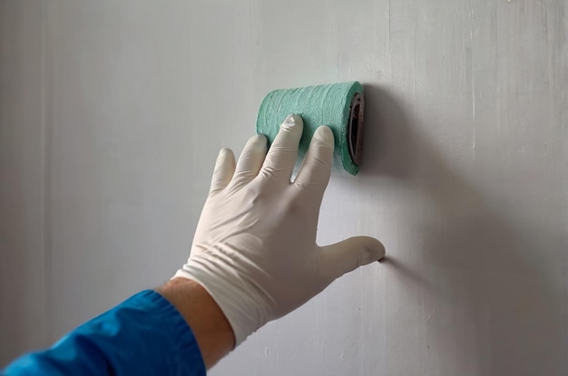 Foto una persona que usa un guante que tiene una toalla verde para pintar