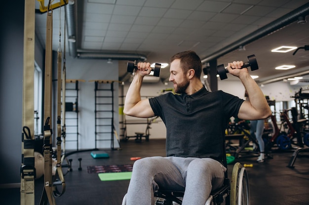 Persona que usa silla de ruedas entrenando en el gimnasio Centro de rehabilitación