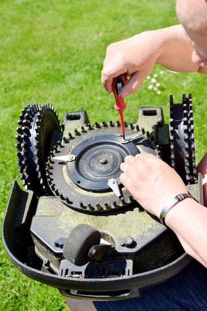 Foto una persona está reparando un cortacésped robótico