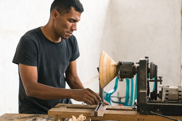 Persona reparando una máquina en su taller. Carpintero realizando mantenimiento en sus herramientas.