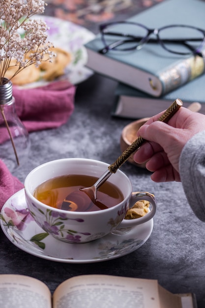 Una persona revolviendo el té con una cuchara