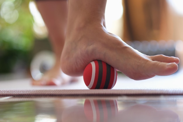 La persona rueda la pelota a pie en el primer plano de la casa