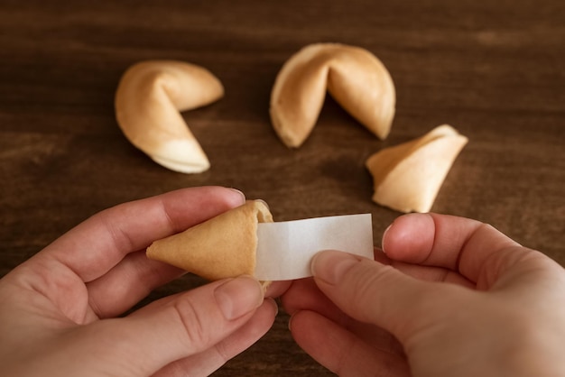 Persona sacando nota en blanco con deseo de buena suerte de maqueta de galleta de la fortuna