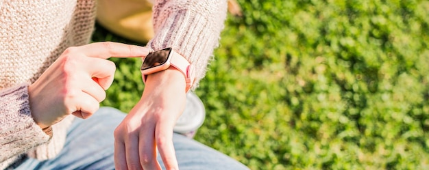 Foto persona del sexo femenino que toca el reloj inteligente mujer que usa aplicaciones en el reloj inteligente pantalla táctil con la mano derecha