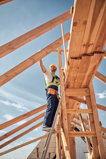 Persona del sexo masculino atento vistiendo uniforme mientras trabajaba en la construcción del desarrollo de viviendas