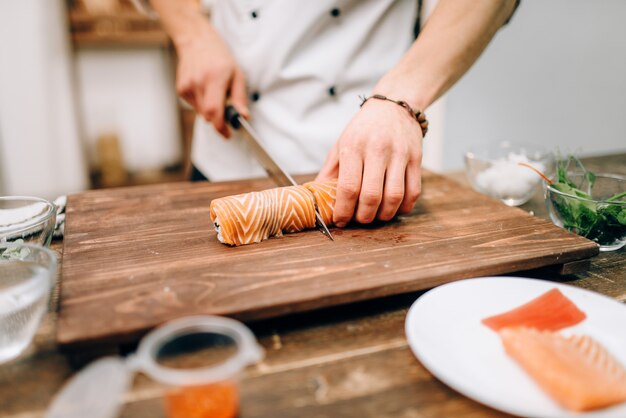 Foto persona del sexo masculino cocinar sushi, comida japonesa