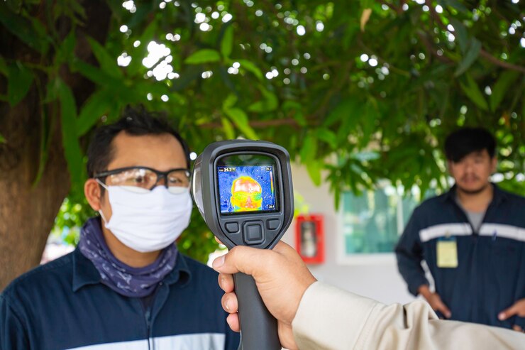 Foto una persona del sexo masculino que se mide la temperatura corporal de escaneo con un infrarrojo sin contacto