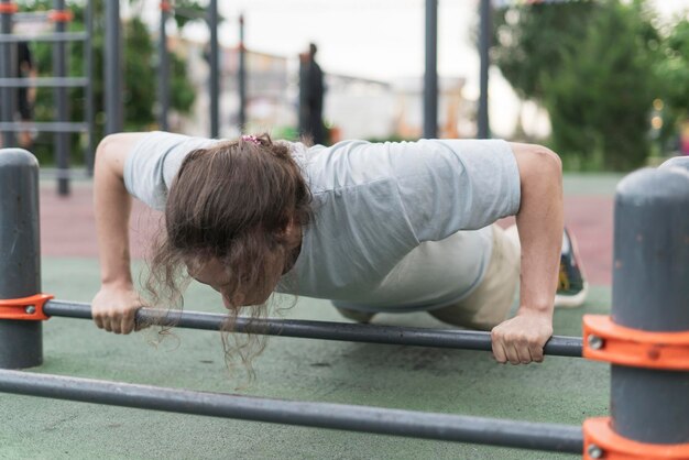 una persona del sexo masculino realizando flexiones en un entorno de parque sereno