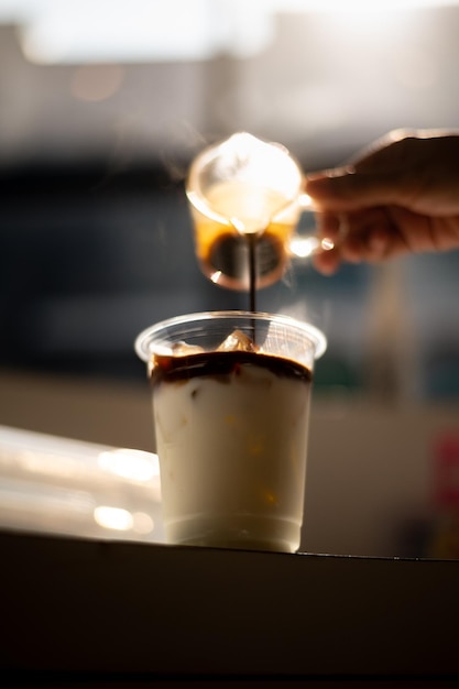 Una persona sirviendo café en una taza.