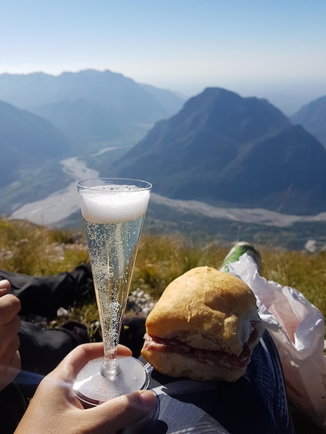 Persona sosteniendo helado contra las montañas