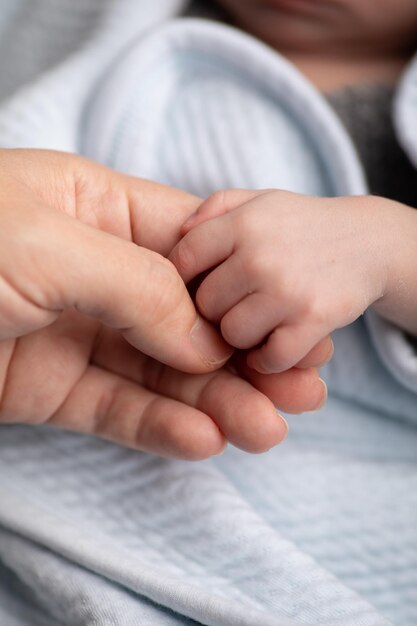 una persona sosteniendo la mano de un bebé con una toalla blanca que dice bebé