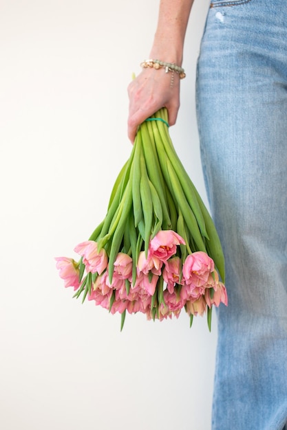 Persona sosteniendo un ramo de tulipanes rosados estilo casual concepto de primavera y día de la madre