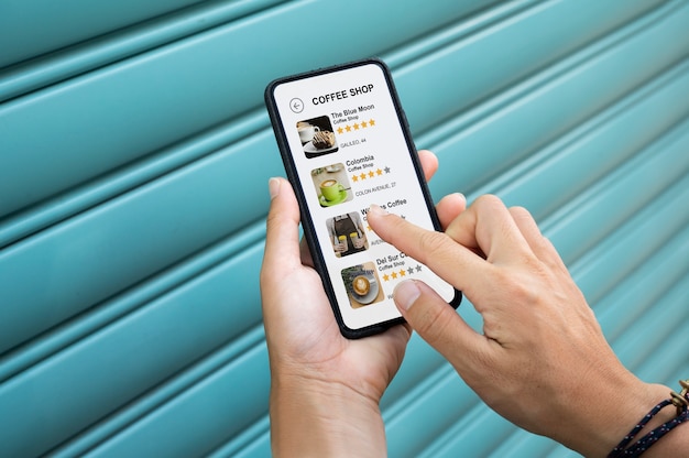 Foto persona sosteniendo su teléfono inteligente con una aplicación en la pantalla