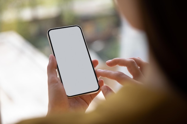 Persona sosteniendo un teléfono inteligente con pantalla en blanco