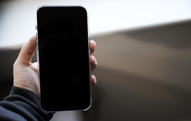 Una persona sosteniendo un teléfono con una pantalla negra que dice "iphone"
