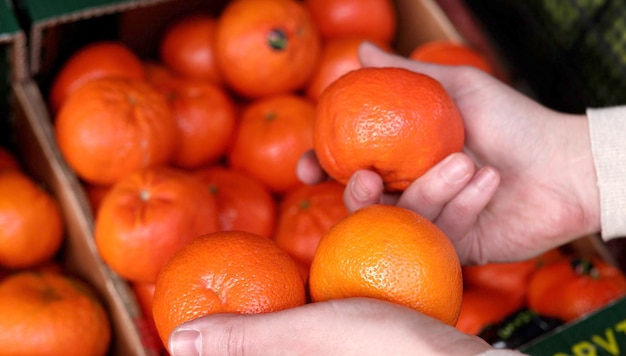 Una persona sostiene una naranja en sus manos.