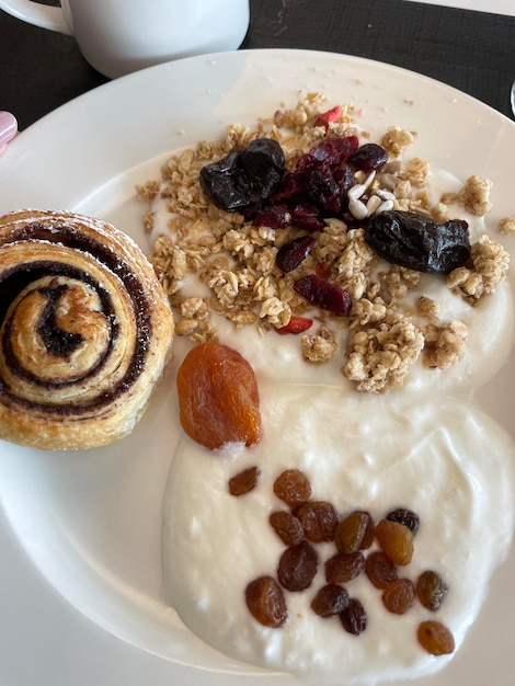 Foto una persona sostiene un plato con avena y pasas.