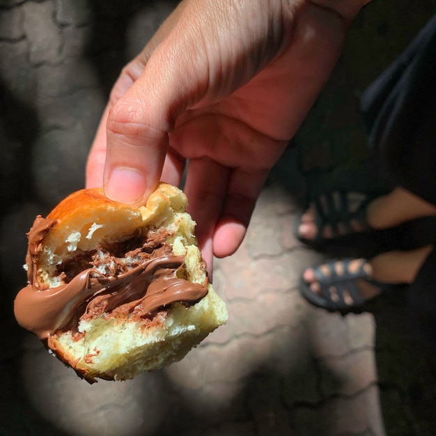 Una persona sostiene un sándwich con relleno de nutella.