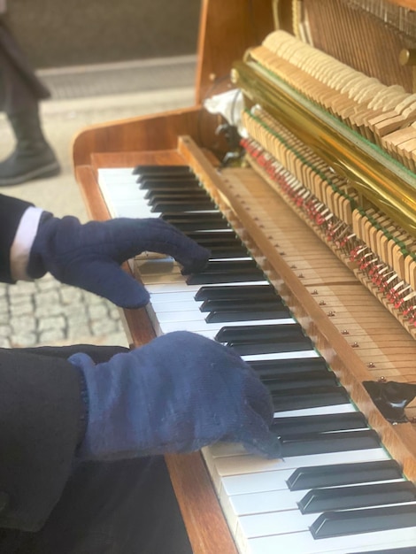 Una persona tocando un piano con un guante en la mano.