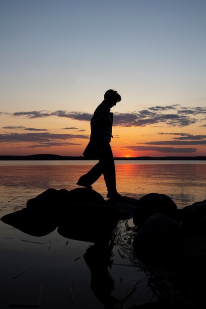 Foto persona triste y contemplativa cerca del lago.