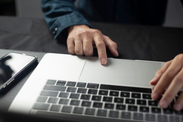 Foto la persona está usando computadoras portátiles para trabajar o estudiar en línea en casa. el hombre de negocios usa una computadora portátil para trabajar fuera de la oficina.