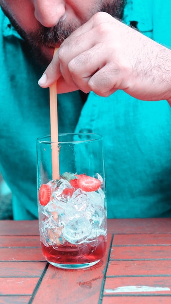 Foto una persona está usando un palo para agitar el hielo en un vaso