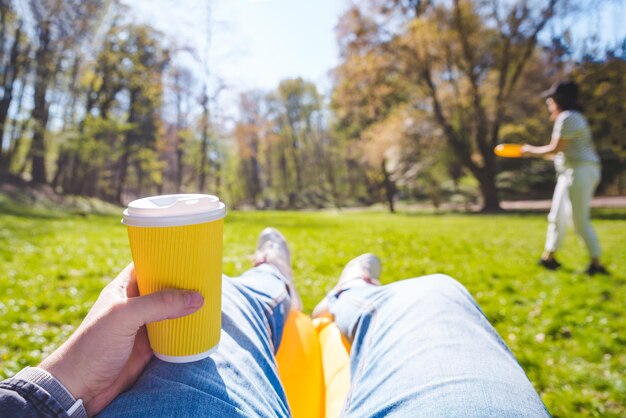 Persona ver hombre tendido en el sofá de aire bebiendo té