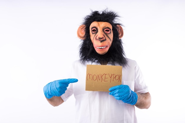 Persona vestida como un mono con una máscara con un traje de enfermera médica con un cartel que dice 39MONKEYPOX39 sobre fondo blanco Epidemia de virus pandémico Concepto de viruela y mono de Nigeria