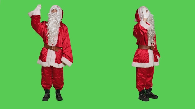 Personagem alegre acenando olá na câmera, cumprimentando as pessoas e espalhando a positividade do natal. Papai Noel dizendo oi enquanto ele está vestindo traje vermelho icônico com chapéu e barba branca.