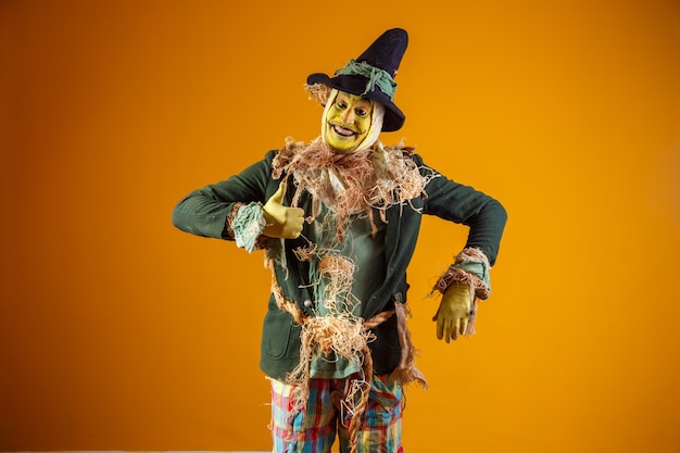 Personaje de espantapájaros de festa junina en pared amarilla