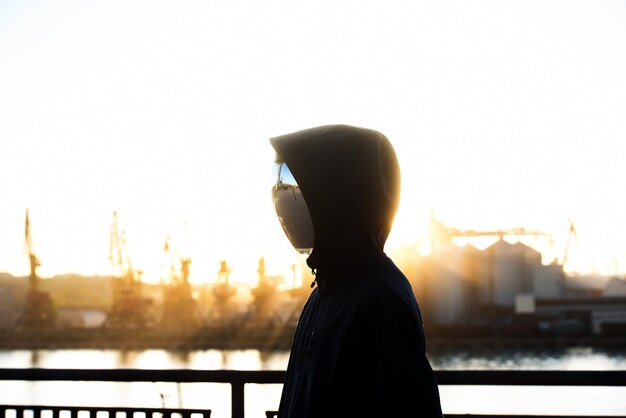 Personaje sin rostro con la máscara de espejo con puerto de fondo