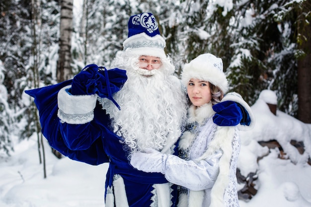 Los personajes rusos de Navidad Ded Moroz (padre Frost) y Snegurochka (doncella de nieve) en un bosque nevado.