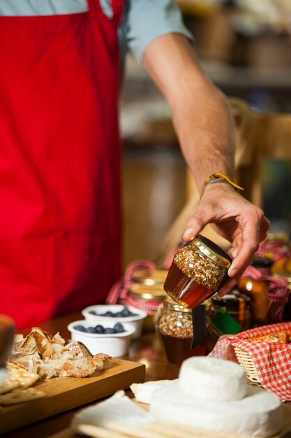 Personal, das Einmachglas am Schalter im Markt überprüft