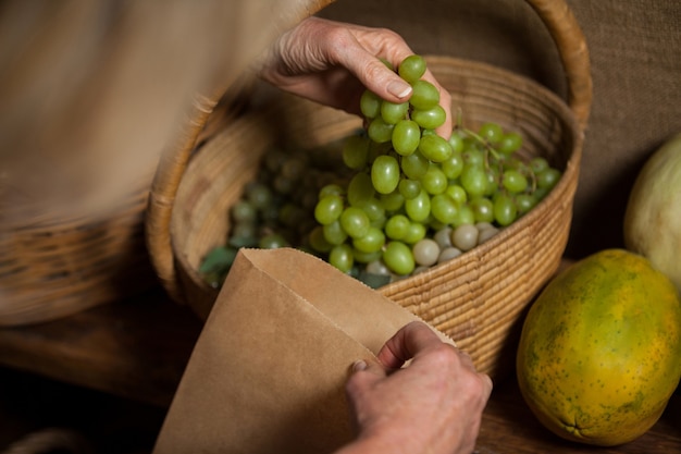 Personal de embalaje de uvas en bolsa de papel