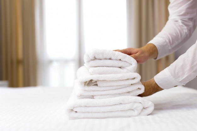 Personal del hotel preparando la almohada en la cama.