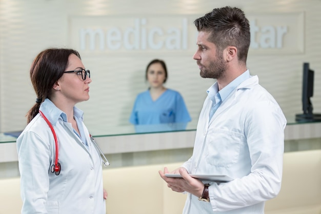 Foto personal médico discutiendo en el moderno pasillo del hospital