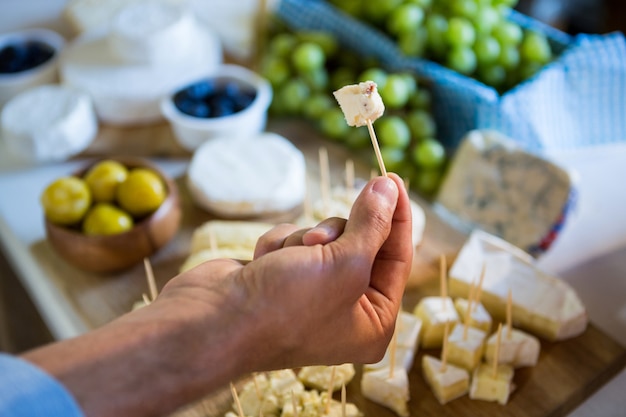 Personal mostrando una muestra de queso al cliente en el mostrador