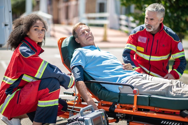 Foto personal paramédico que brinda atención de emergencia a una víctima de accidente automovilístico