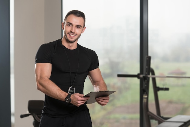 Foto personal trainer macht sich notizen in der zwischenablage