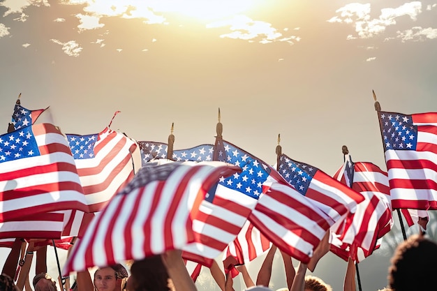 Personas con banderas americanas frente a una puesta de sol